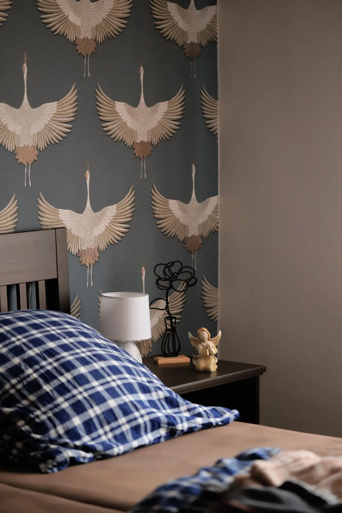 Bedroom with a slate-blue crane-motif wallpaper behind the headboard