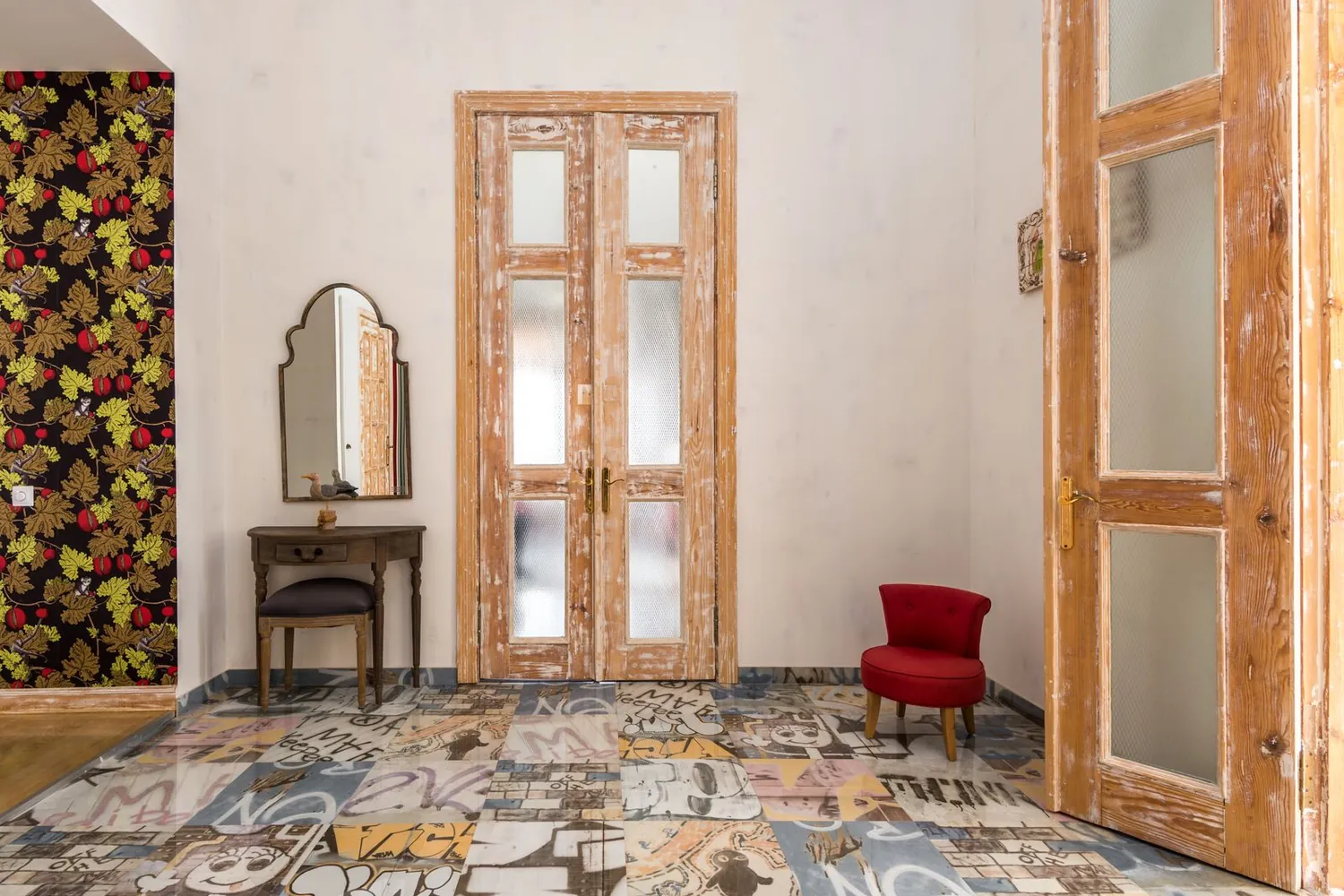 Reception room with a dark floral feature wall, timber French doors, and a patterned tile floor